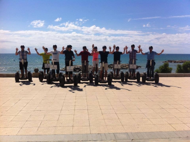 Amigos sobre los segways en el paseo marítimo